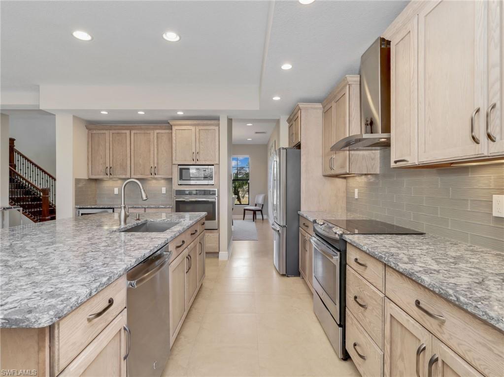 3160 27th Avenue Southwest Naples, FL 34117 - Photo 14 of 43 a large kitchen with stainless steel appliances granite countertop a sink stove and refrigerator