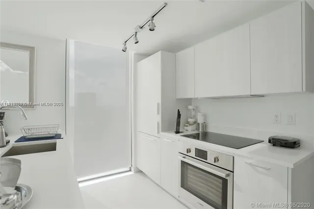 a kitchen with a refrigerator stove and white cabinets