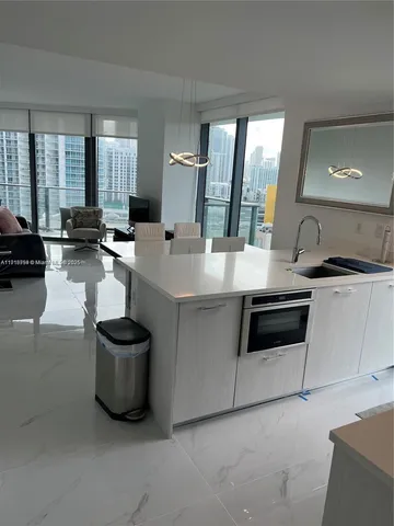 a large white kitchen with a stove and a sink