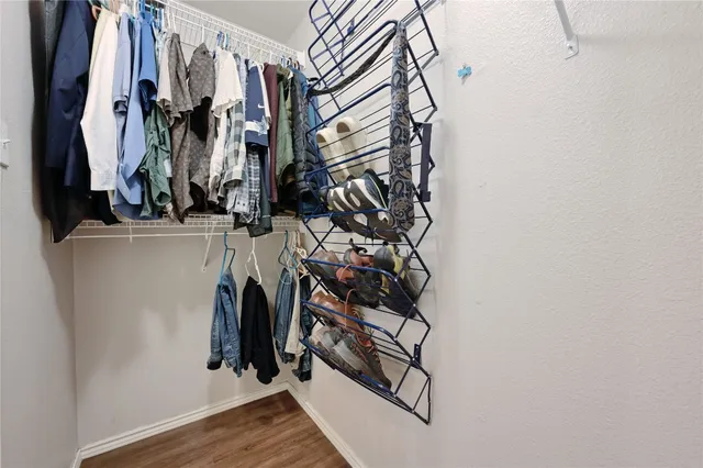 a view of walk in closet with clothes and shoes