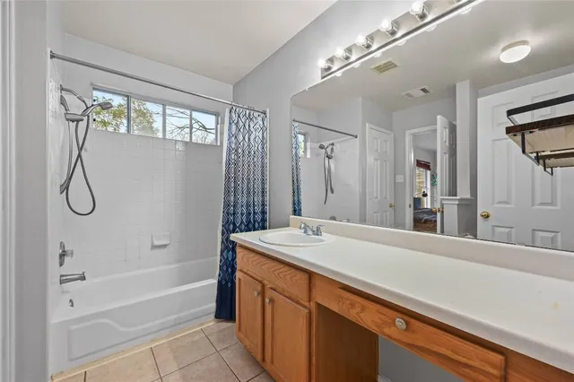a bathroom with a granite countertop sink a mirror and a bathtub