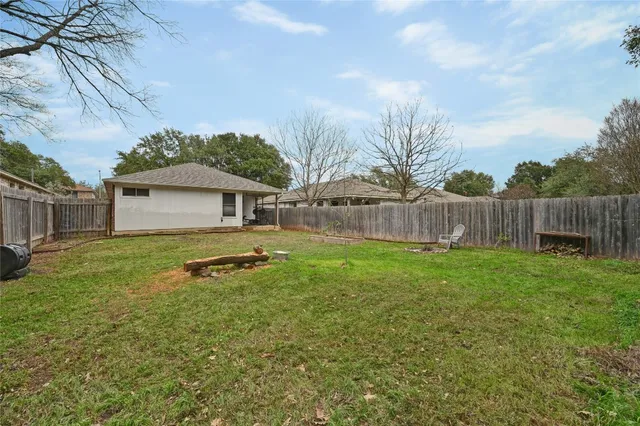 a backyard of a house with table and chairs