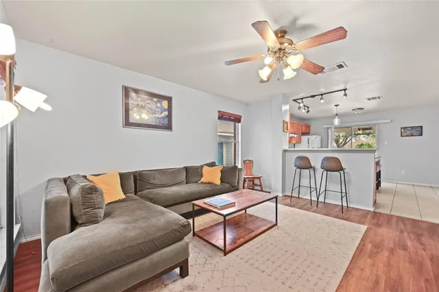 a living room with furniture a chandelier and a wooden floor