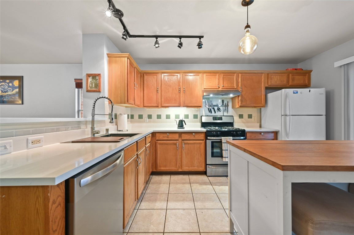 1709 Friars Tale Lane Austin, TX 78748 - Photo 8 of 24 a kitchen with a sink a stove a refrigerator and a refrigerator