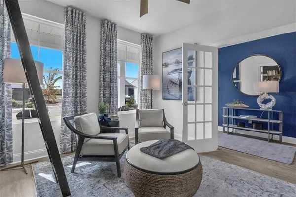 a living room with furniture and a floor to ceiling window
