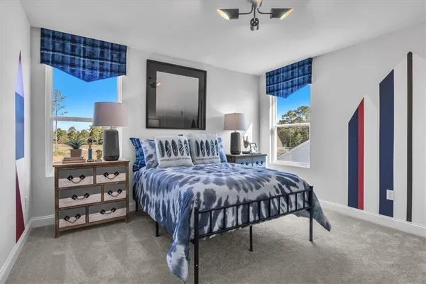 a bedroom with a bed a dresser and window