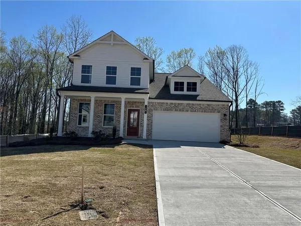 a front view of a house with yard and trees