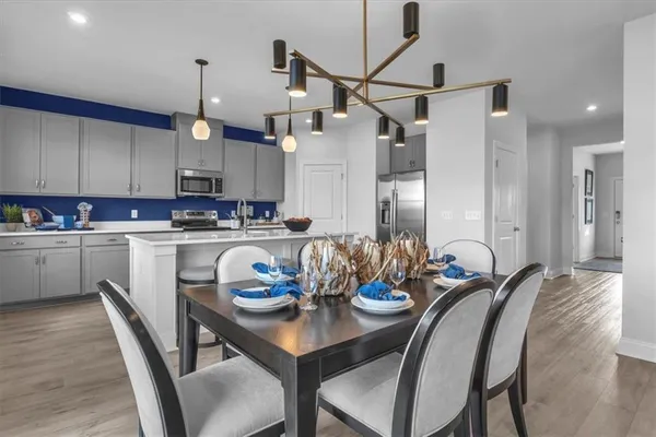 a kitchen with a dining table chairs sink and cabinets