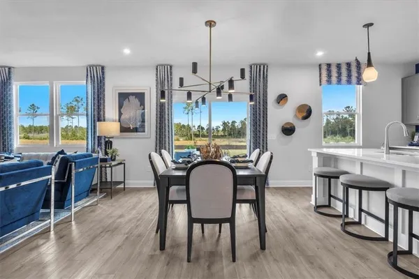 a dining room with furniture a chandelier and wooden floor