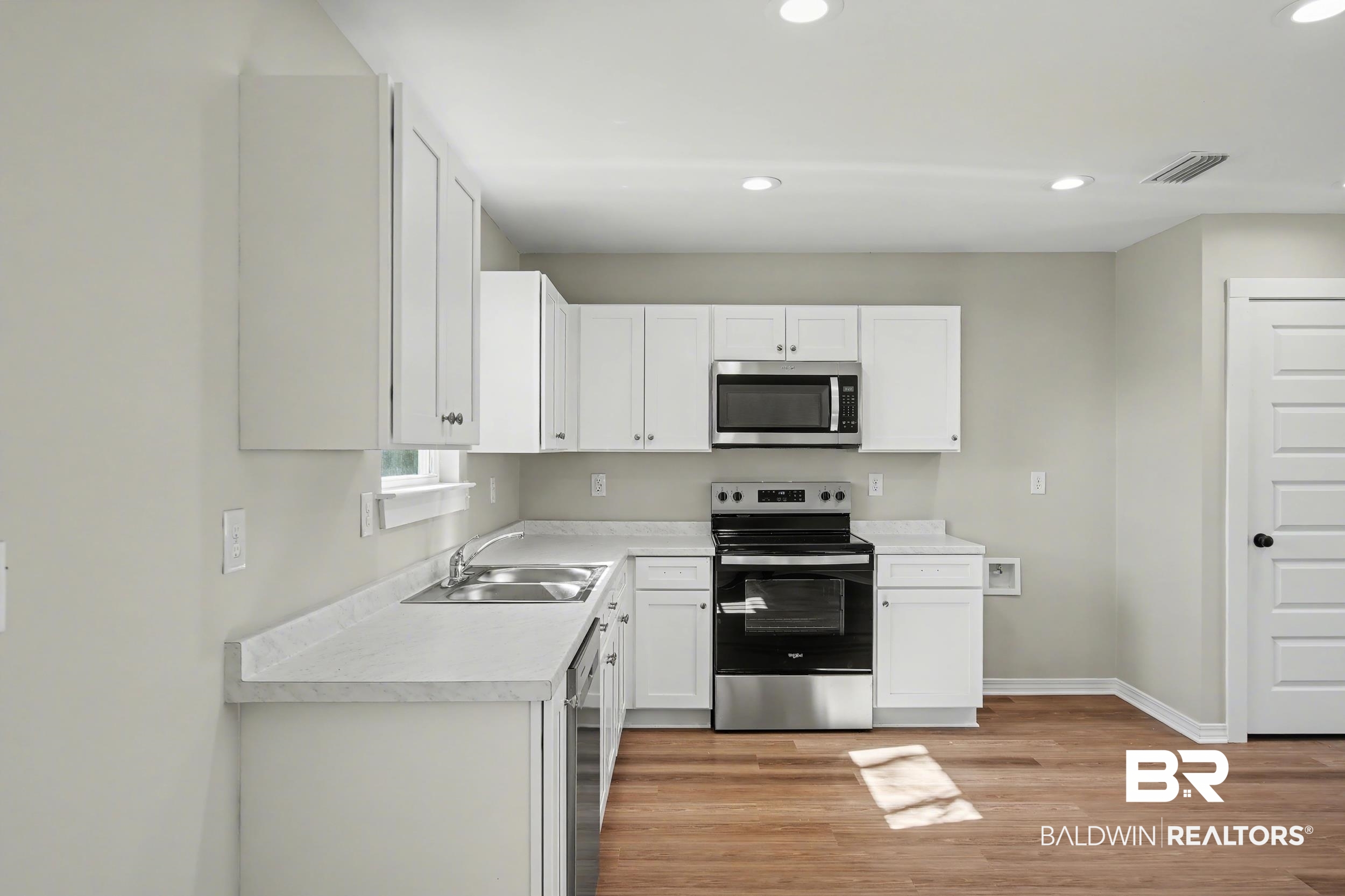 76 Fincher Lane Loxley, AL 36551 - Photo 12 of 33 Kitchen with stainless steel appliances, white cabinetry, light countertops, light wood finished floors, and recessed lighting