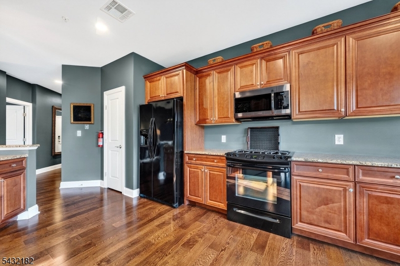 119 River Road Somerville, NJ 08876 - Photo 11 of 30 a kitchen with stainless steel appliances granite countertop a stove top oven a refrigerator and a granite counter tops with wooden floors