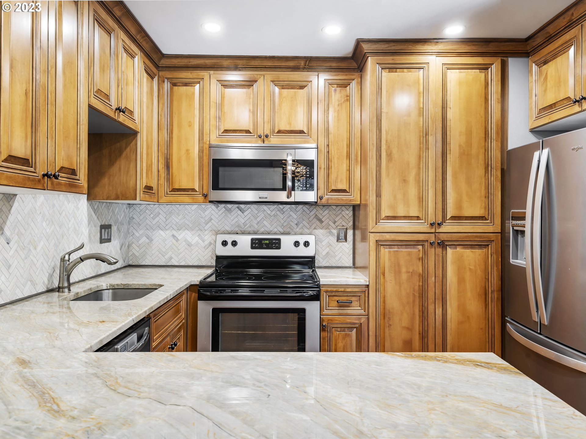 3851 Southwest Canby Street Portland, OR 97219 - Photo 15 of 32 a kitchen with stainless steel appliances granite countertop a refrigerator a sink and a stove
