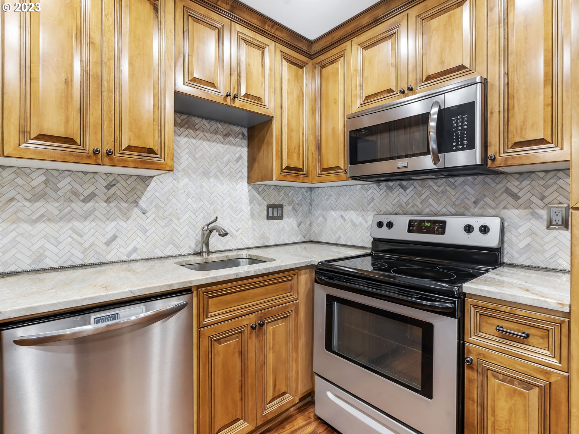 3851 Southwest Canby Street Portland, OR 97219 - Photo 17 of 32 a kitchen with stainless steel appliances a stove microwave and sink