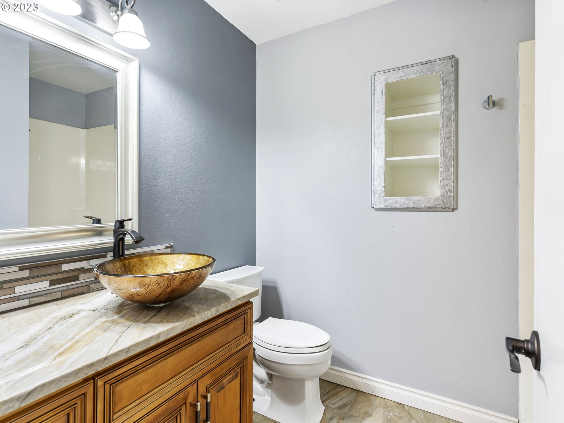 3851 Southwest Canby Street Portland, OR 97219 - Photo 18 of 32 a bathroom with a granite countertop toilet sink and mirror