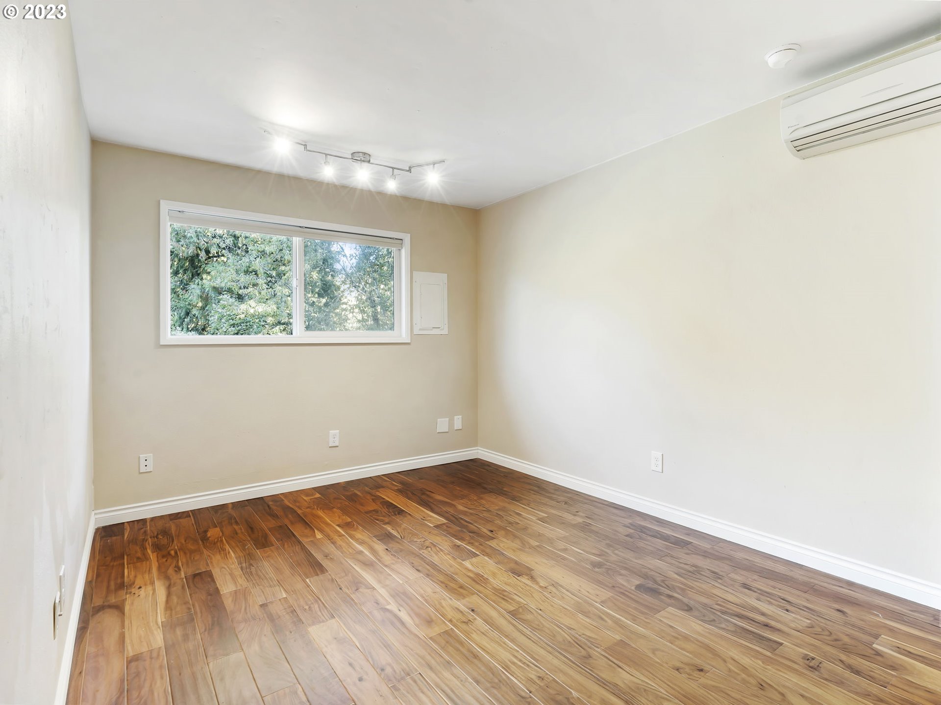 3851 Southwest Canby Street Portland, OR 97219 - Photo 19 of 32 an empty room with wooden floor and windows