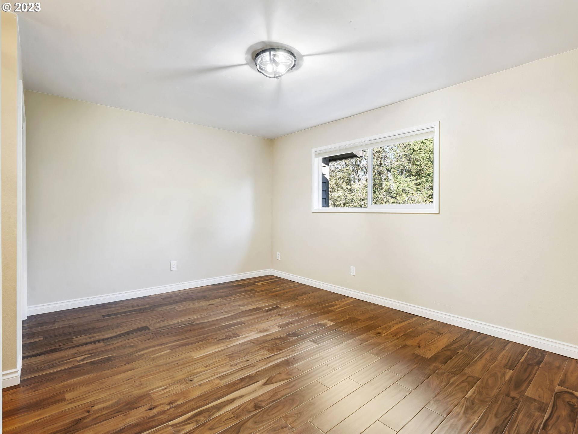 3851 Southwest Canby Street Portland, OR 97219 - Photo 22 of 32 an empty room with wooden floor and windows