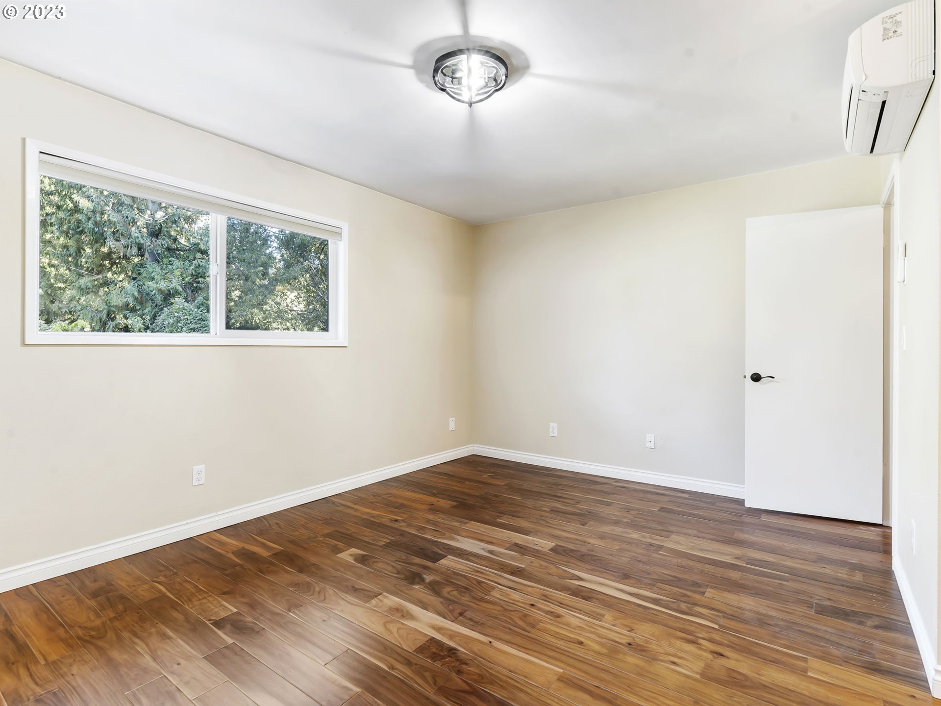 3851 Southwest Canby Street Portland, OR 97219 - Photo 25 of 32 an empty room with wooden floor and windows