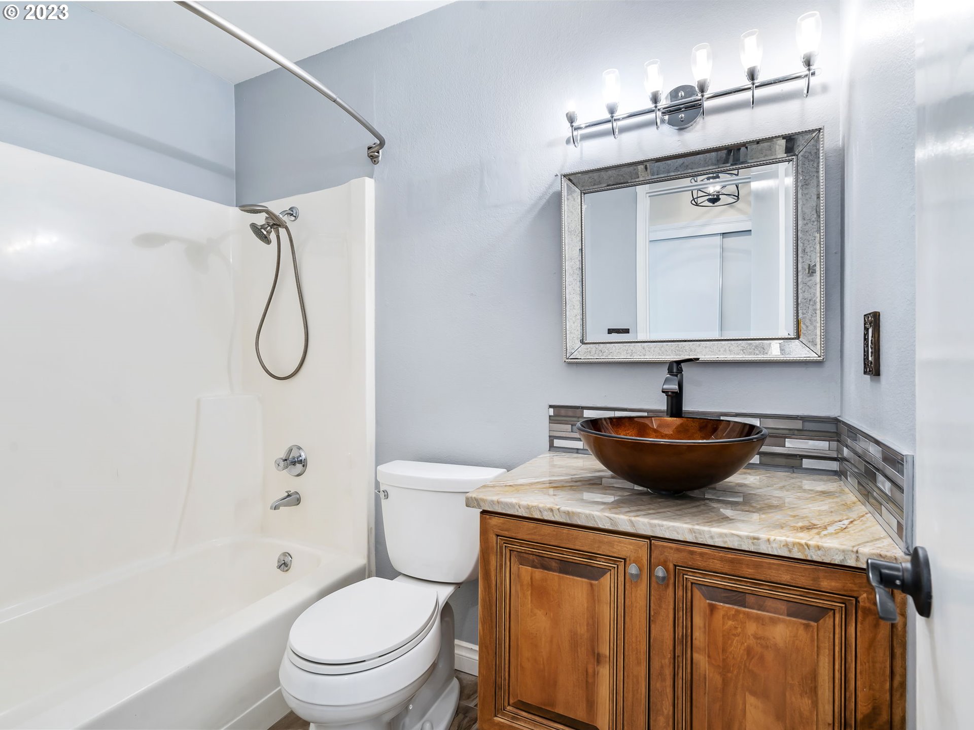 3851 Southwest Canby Street Portland, OR 97219 - Photo 27 of 32 a bathroom with a granite countertop sink a toilet and a mirror