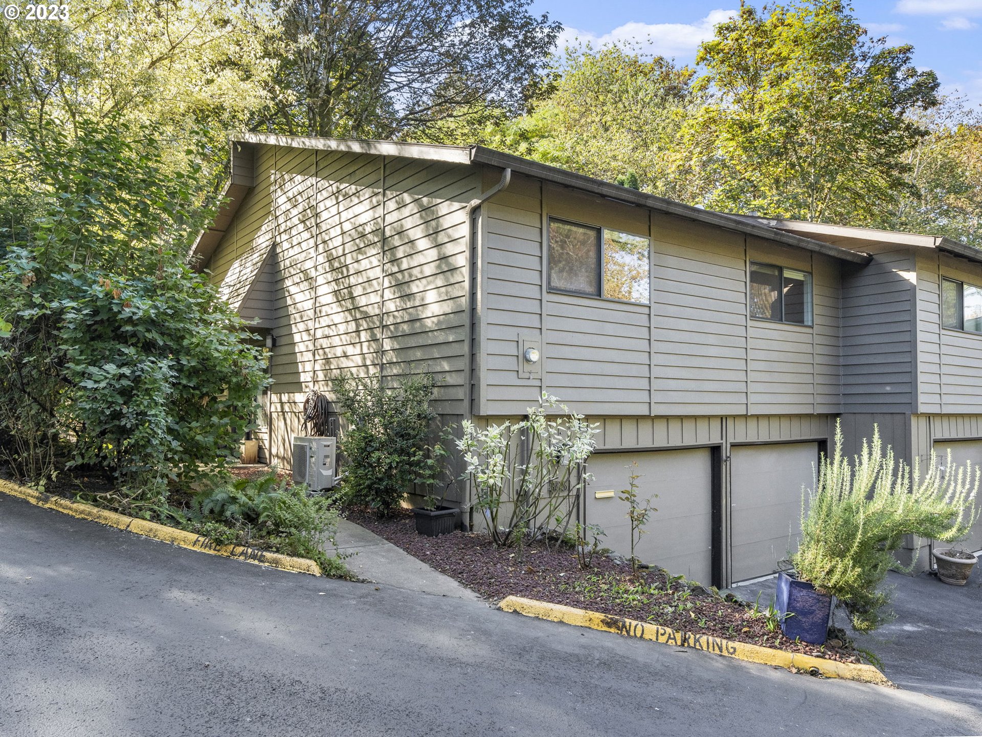 3851 Southwest Canby Street Portland, OR 97219 - Photo 3 of 32 a front view of a house with a yard and garage
