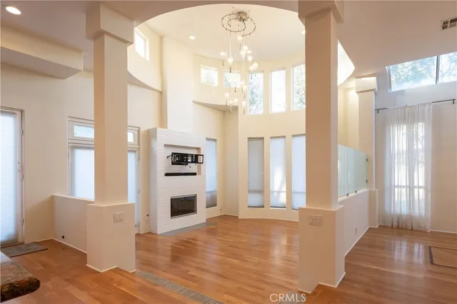 a view of a big room with windows and chandelier