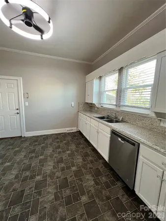 a kitchen with a sink a stove cabinets and a window
