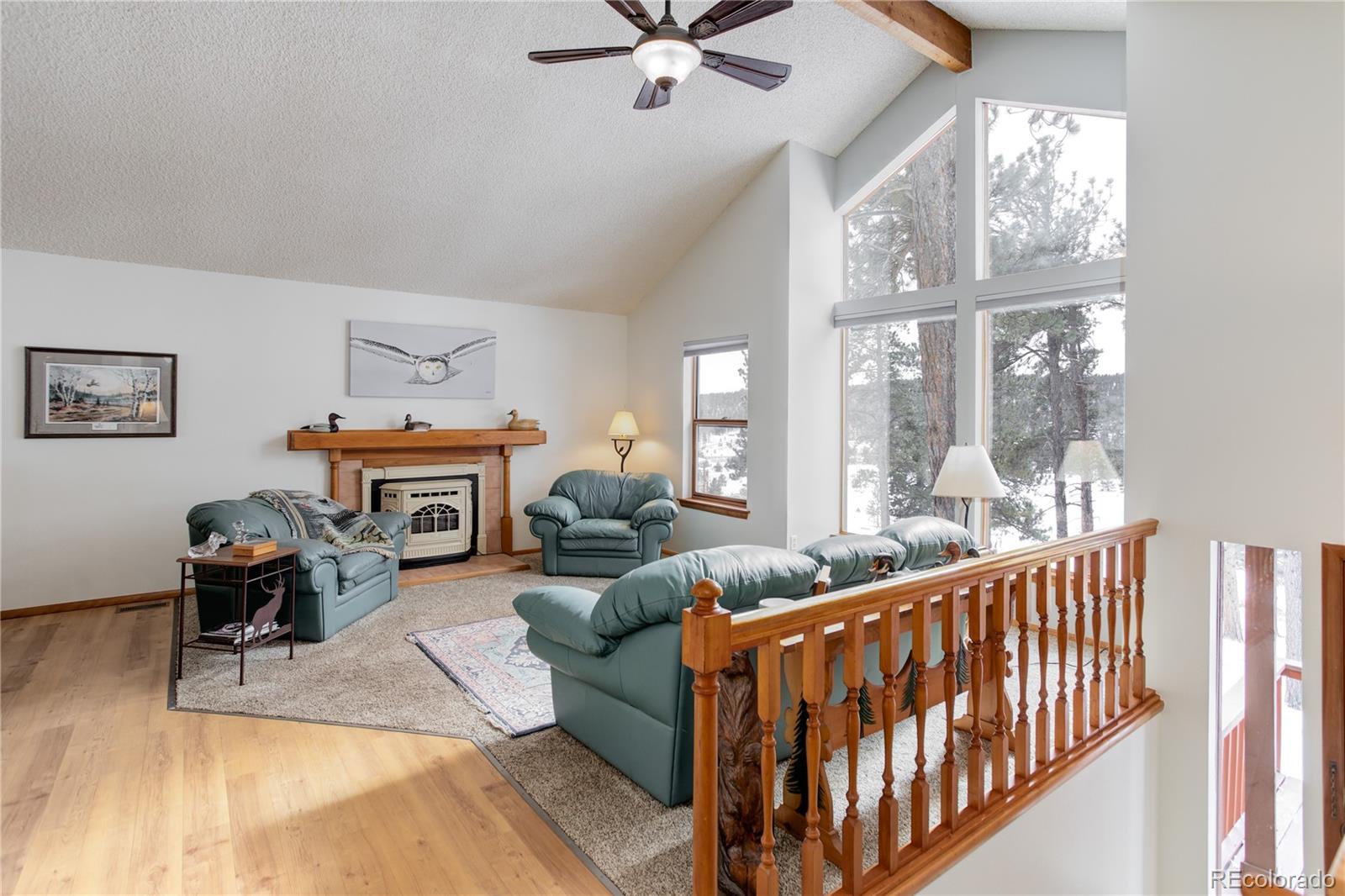129 Bulldogger Road Bailey, CO 80421 - Photo 28 of 40 a living room with furniture a fireplace and a floor to ceiling window