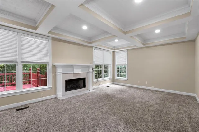 a view of an empty room with a fireplace and a window