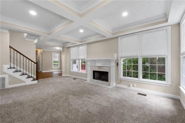 an empty room with fireplace and stairs