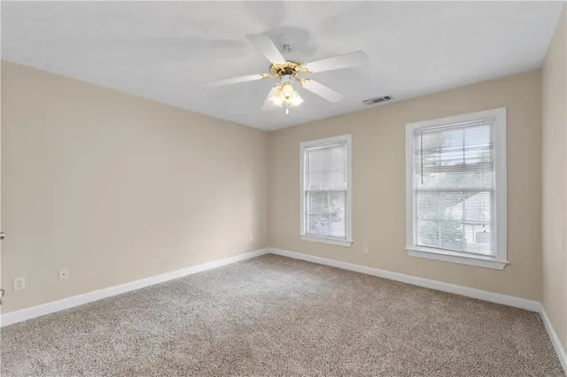 an empty room with a window and a fan
