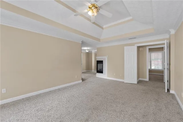 an empty room with windows and chandelier fan