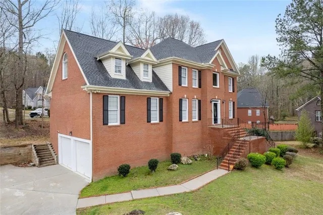 a view of a house with a yard and wooden fence
