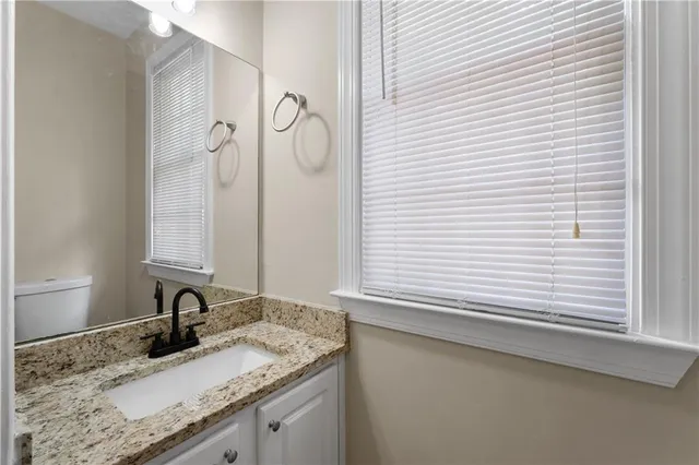 a bathroom with a granite countertop sink and a mirror