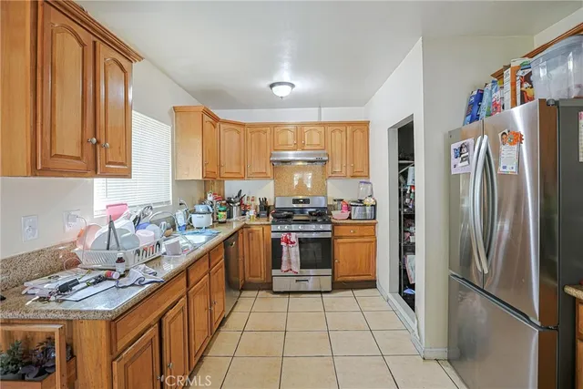a kitchen with stainless steel appliances granite countertop a refrigerator and a sink