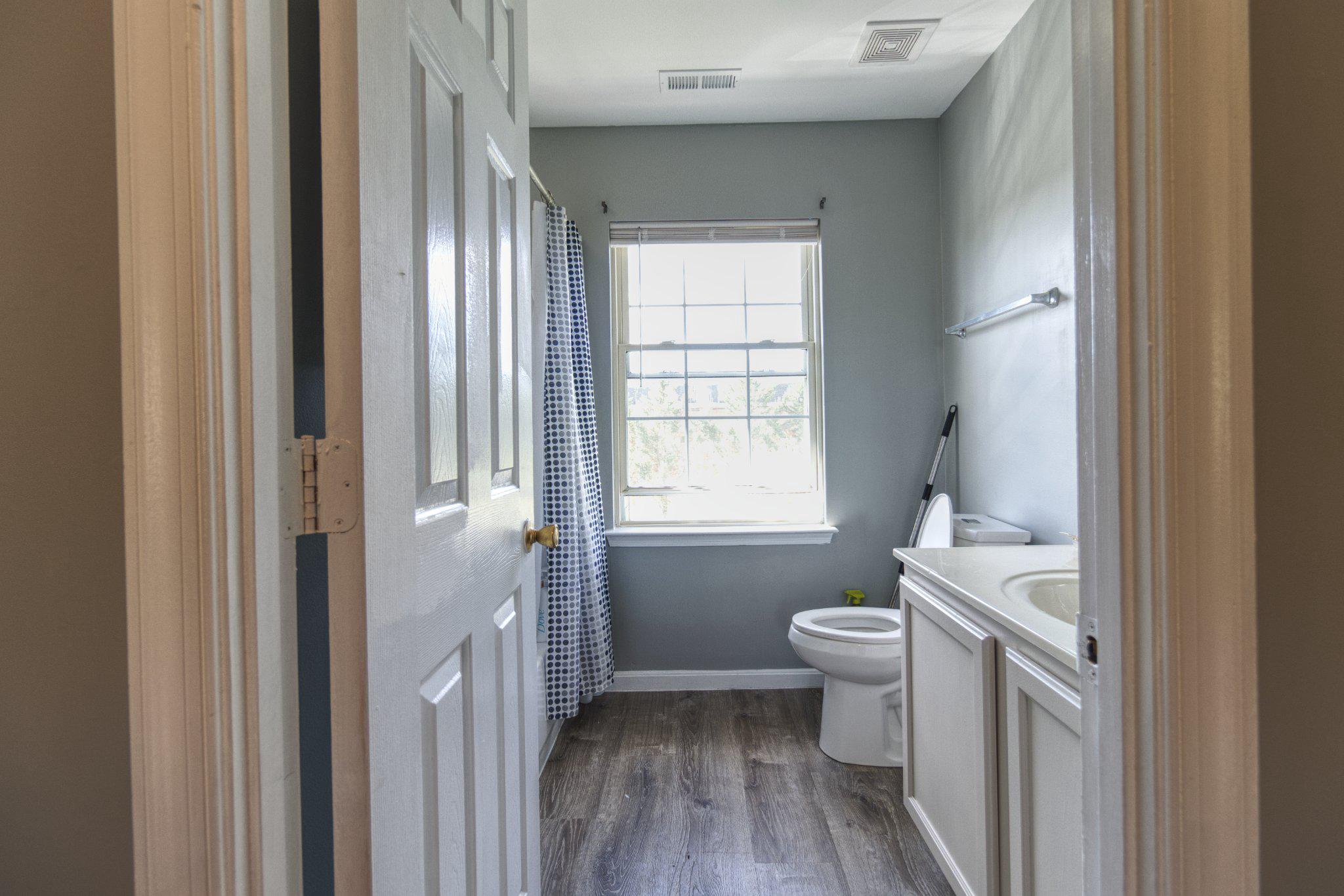 215 Seamaster Road Essex, MD 21221 - Photo 18 of 40 a bathroom with a sink a toilet a window and a mirror