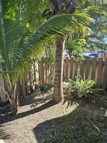 front view of a house with a yard and potted plants