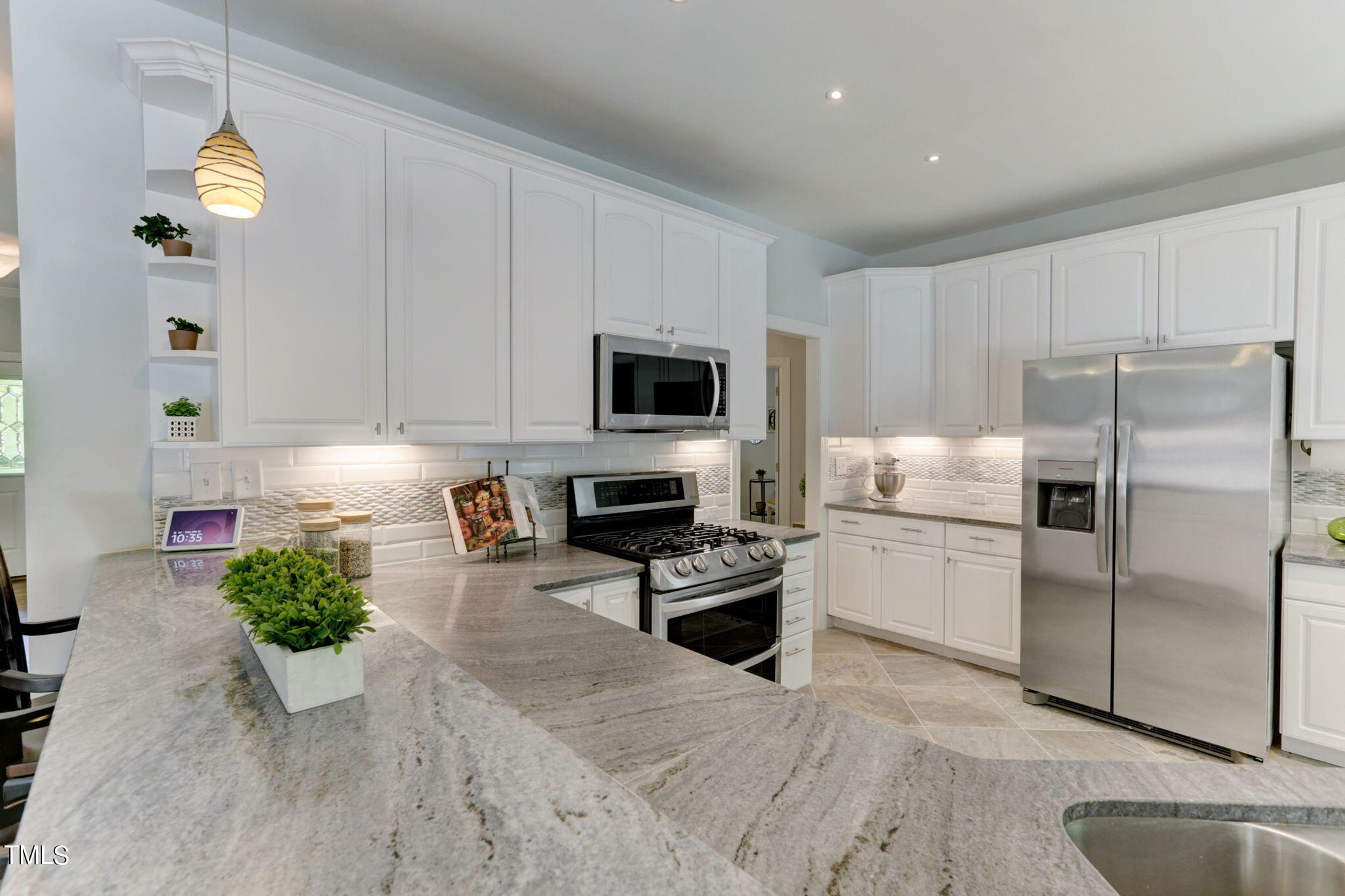 1029 Sunset Meadows Drive Apex, NC 27523 - Photo 27 of 52 a kitchen with a refrigerator a microwave a stove and cabinets