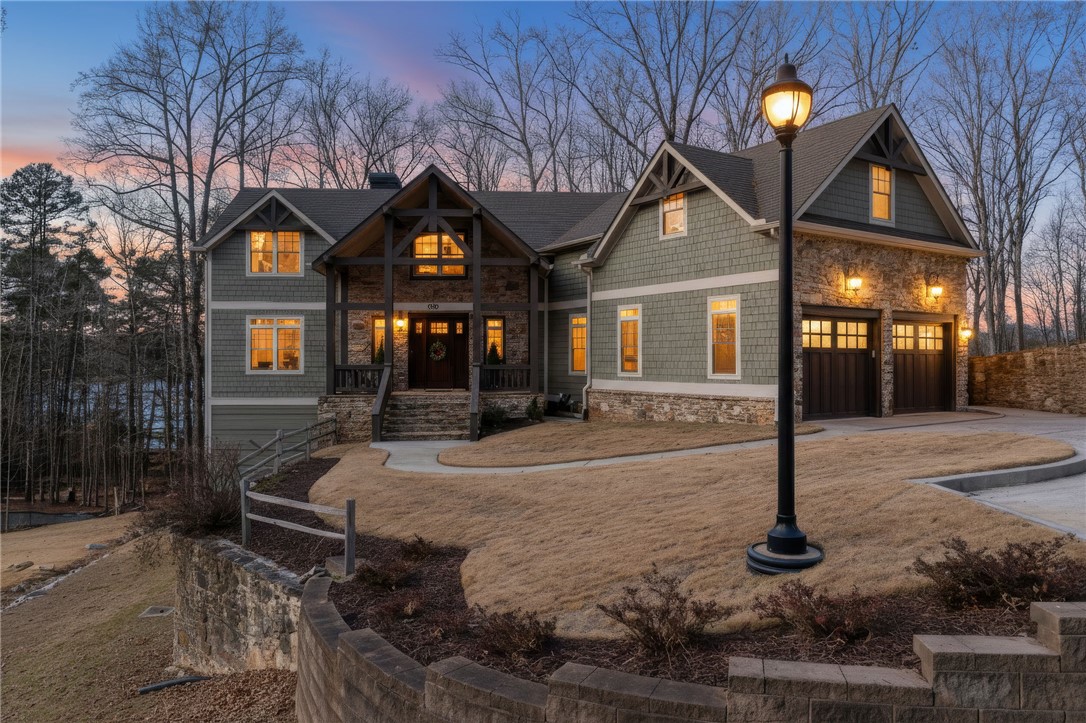 This exquisite lakefront residence features a stone and shingle facade, offering timeless curb appeal.