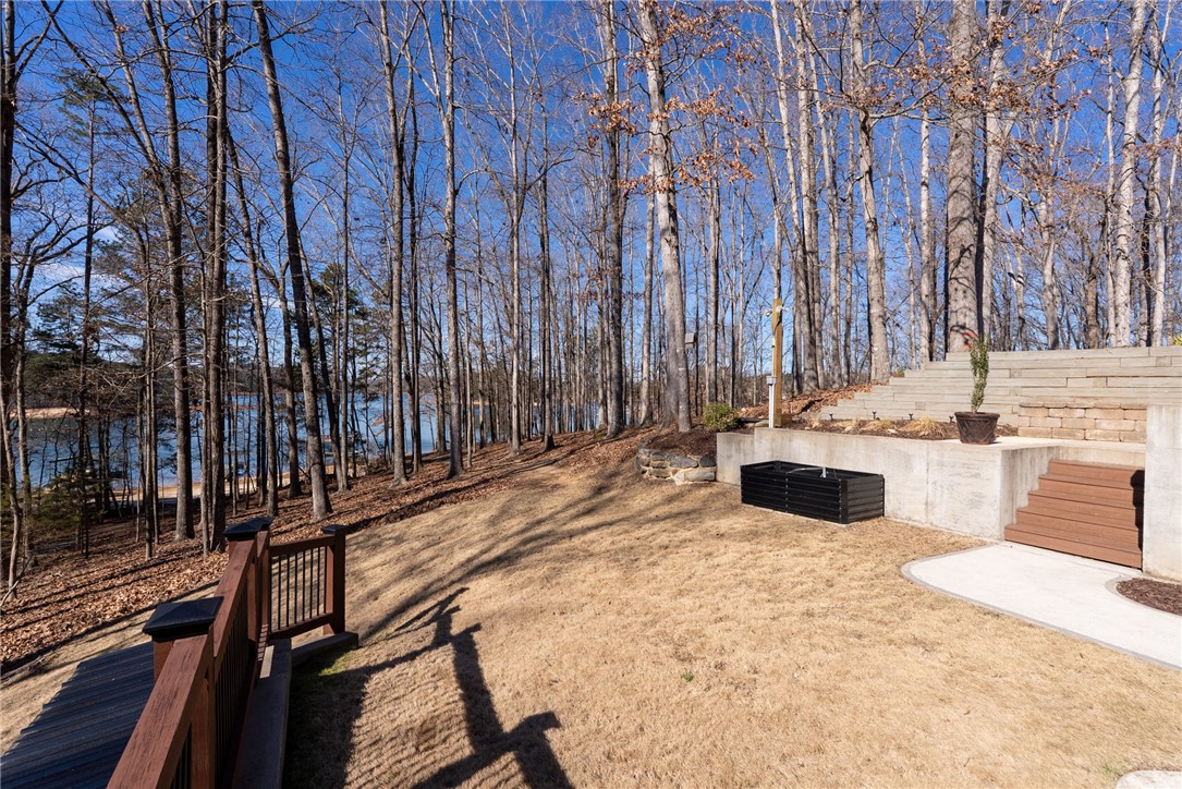 505 Northview Court Fair Play, SC 29643 - Photo 43 of 48 This tranquil yard features mature trees, a deck, and tiered landscaping leading to a serene lake.