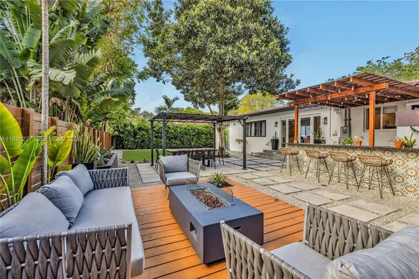 a view of a patio with couches table and chairs and potted plants