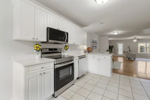 a kitchen with stainless steel appliances kitchen island granite countertop a sink and cabinets