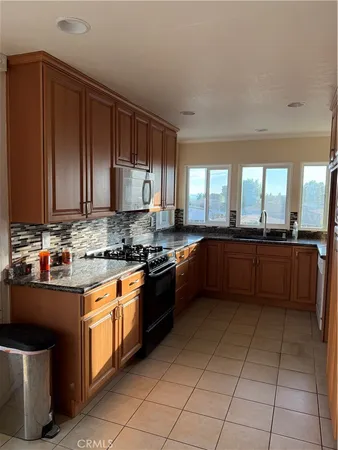 a large kitchen with stainless steel appliances granite countertop a stove a sink dishwasher and a refrigerator