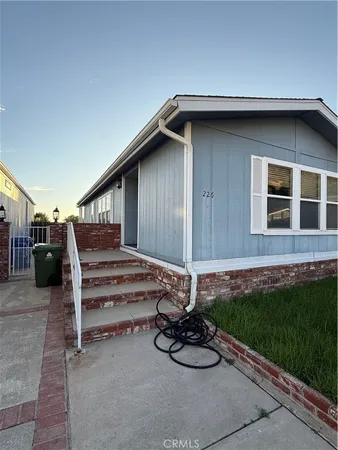a wooden bench sitting in front of a house
