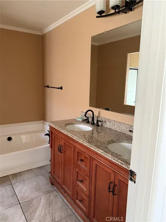 a bathroom with a granite countertop sink a mirror and a bathtub