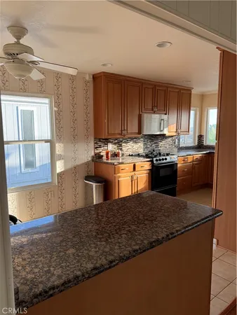 a kitchen with stainless steel appliances granite countertop a stove a sink and a microwave