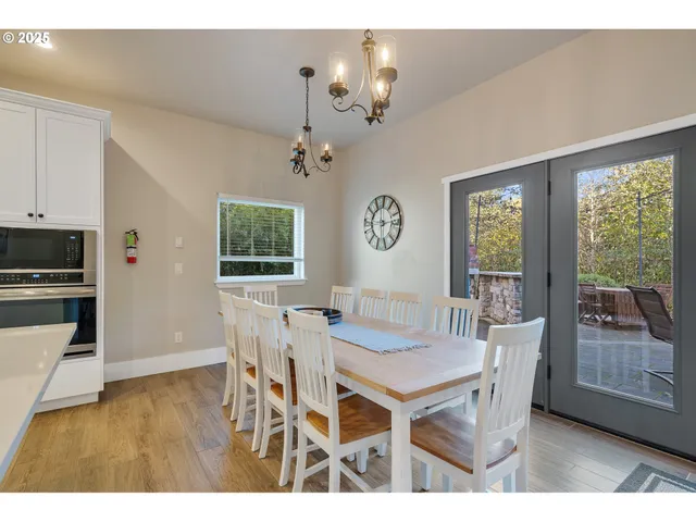 a dining room with furniture a chandelier and wooden floor