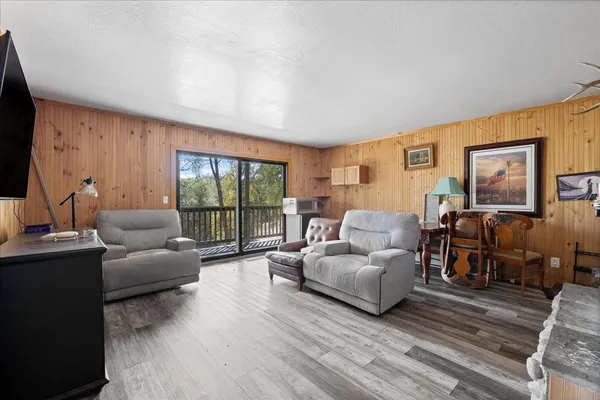 a living room with furniture a flat screen tv and a floor to ceiling window