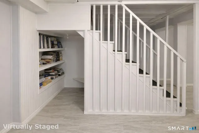 a view of a hallway with wooden floor and staircase