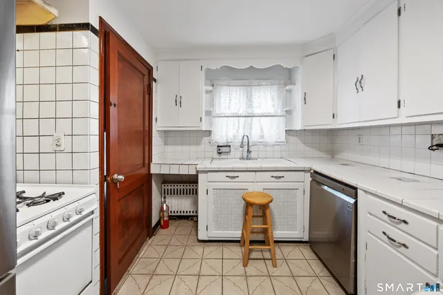 a kitchen with granite countertop white cabinets and white appliances