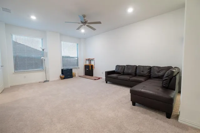 a living room with furniture and a ceiling fan