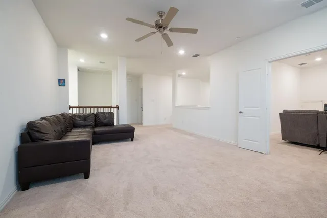 a living room with furniture and a ceiling fan